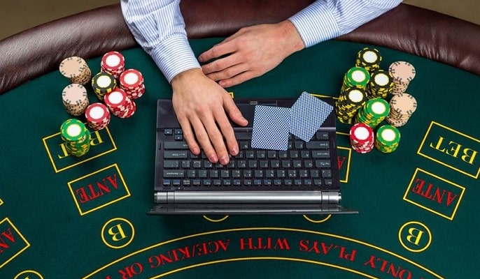 miehet, jotka pelaavat online-kasinopelaa kannettavalla tietokoneella